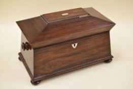 A ROSEWOOD TEA-CADDY of sarcophagus form on four bun feet, beading decorated with mother-of-pearl