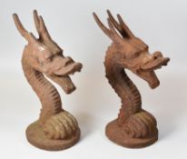 A PAIR OF IRON WORK GATEPOST HEADS in the form of serpent creature heads, 34cms high
