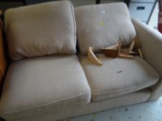 A modern two-seater sofa with side stool in an oatmeal coloured fabric together with a brown