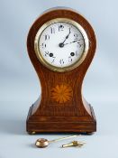 AN INLAID AMERICAN WALNUT BALLOON SHAPED MANTEL CLOCK having a white enamel dial set with Arabic