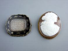 A VICTORIAN MOURNING BROOCH with central plaited hair panel in a black enamel and gilt metal