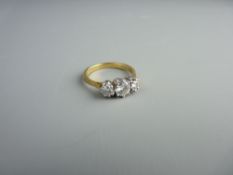 AN EIGHTEEN CARAT GOLD THREE STONE DIAMOND(2) & MOISSANITE(1) RING having a centre round cut