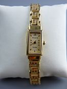 A LADY'S NINE CARAT GOLD ENCASED OBLONG DIAL ACCURIST WRISTWATCH with nine carat gold Grecian Key