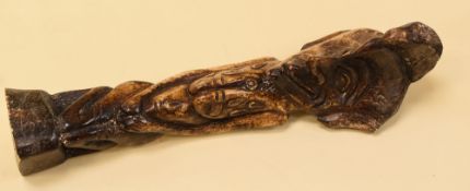 A carved fertility figure believed in bone, partial label on base speculating the bone to be human