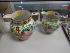A pair of early nineteenth century Swansea creamware pottery jugs with floral decoration and