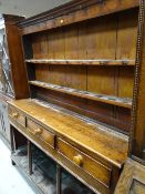 A nineteenth century Welsh dresser having a platform base, three drawers and two-shelf rack (some