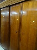 A suite of Stag Minstrel bedroom furniture comprising two wardrobes, bedside table and chest