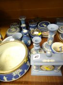 A quantity of blue Wedgwood Jasperware table items including mantel clock, salad bowl, candlestick
