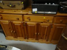 A pine sideboard composed of three drawers and six cupboard doors