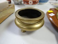 A nineteenth century polished bronze Chinese miniature tri-footed censer with marks to the base