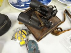 A cased set of vintage Carl Zeiss binoculars and two motoring grill badges