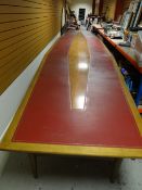 An exceptionally large light wood boardroom table with tapering ends and having a split-leather