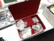 A silver coloured casket with raised decoration containing loose coinage including commemorative