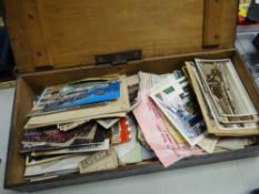 A narrow rectangular wooden box containing postcards and ephemera