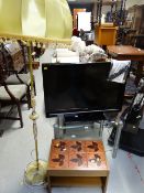 A Sharp flatscreen TV and glass stand together with an onyx effect standard lamp and shade and