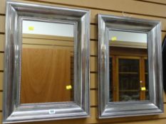 A pair of modern silver metal framed wall mirrors