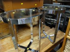 A pair of chrome and circular glass topped side tables