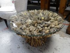 A circular glass topped and 'driftwood based' coffee table