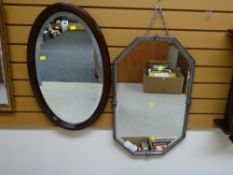 A vintage mahogany framed oval bevelled wall mirror together with a vintage octagonal metal framed
