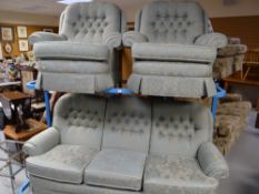 A good quality button backed three-piece suite in green floral upholstery