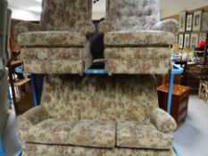 A three-piece suite in floral upholstery