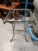 A small ram's head decorated two glass shelved side table