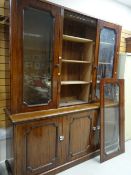 A large mahogany three glass door topped bookcase cupboard