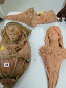 Two Art Nouveau-style terracotta garden wall pockets together with a similar water feature