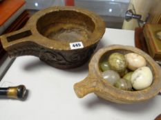 Two stone carved eating vessels and a quantity of carved marble eggs