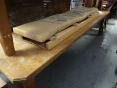 A large extending light oak office / dining table on castor legs