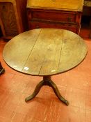 AN ANTIQUE OAK CIRCULAR TOP TRIPOD TABLE, the 75 cms diameter top on a turned column tripod base