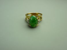 AN EIGHTEEN CARAT GOLD APPLE GREEN JADITE & DIAMOND DRESS RING having an oval cabochon solitaire,