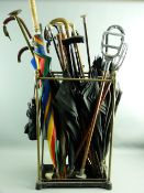 A VINTAGE BRASS & IRON SIX SECTION STICKSTAND and contents to include walking canes, umbrellas,