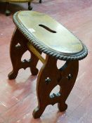 AN ARTS & CRAFTS STYLE MAHOGANY STOOL, the oval top with carrying aperture and rope twist edge