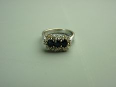 AN EIGHTEEN CARAT WHITE GOLD DIAMOND & SAPPHIRE DRESS RING, the basket type setting with three
