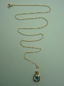 A NINE CARAT GOLD BLUE TOPAZ PENDANT in a racquet shaped frame and with a fine link chain (A/F),