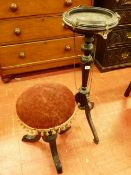 AN EBONIZED EMPIRE STYLE BOWL STAND and a rise and fall piano stool with circular top, the stand