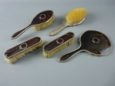 A FIVE PIECE SILVER & TORTOISESHELL BACKED DRESSING TABLE SET of hand mirror and two pairs of