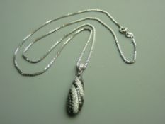 A NINE CARAT WHITE GOLD BOMBE DESIGN BLACK & WHITE DIAMOND PENDANT, approximately fifty eight tiny