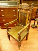 A 1930's CARVED OAK ANGLESEY EISTEDDFOD CHAIR, the shaped top rail with carved leeks and spindle