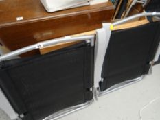 A pair of metal framed and canvas garden chairs together with a wallpaper table