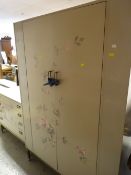 A vintage three-piece bedroom suite with flower painted fronts and on raised chrome feet together