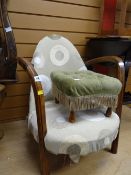A low wooden framed and upholstered armchair together with a footstool