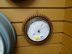 A vintage circular carved oak rope patterned surround barometer made by B & A Butterfield of