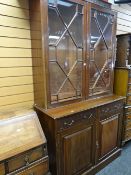 A large mahogany astragal glazed topped cupboard bookcase with carving to drawer fronts