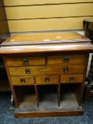 A nice low oak standing cabinet with brass handled drawers, pigeon holes and lidded top