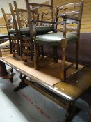 A good dark oak refectory-style dining table together with a set of six matching ladder back and