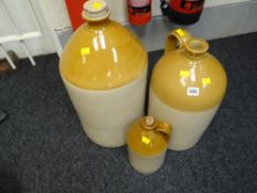 A large stone glazed jar together with two stone glazed bottles