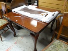 An antique mahogany extending dining table