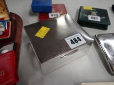 A machine turned hinging silver cigarette box circa 1930s together with a silver whisky label